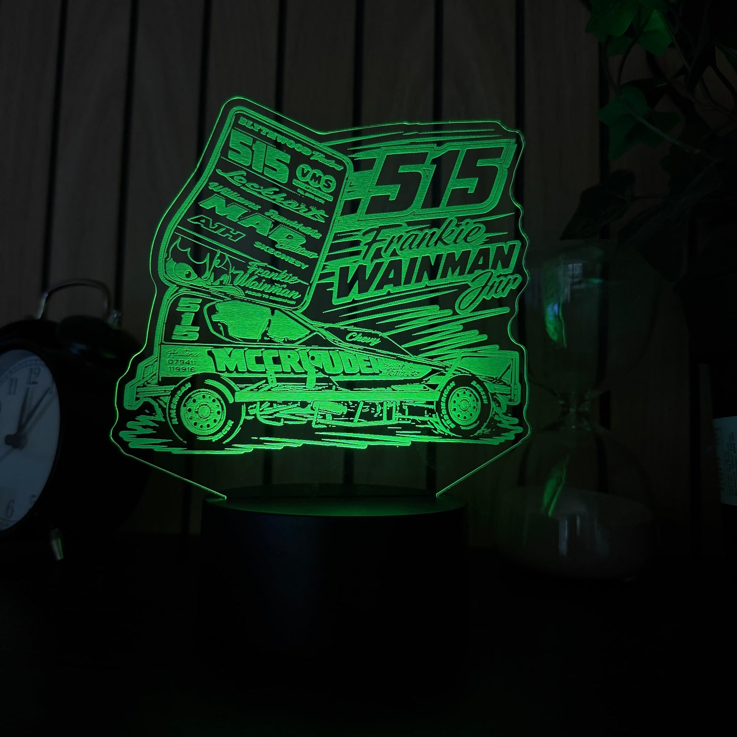 Green neon sign of a truck on a wooden surface laser cutout of a geometric design on a dark surface of 515 frankie wainmann jnr stockcar and banger racing merchandise and night light